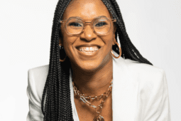 Smiling woman in white suit.