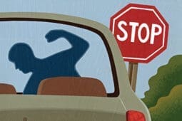 An angry young man in a car at a stop sign