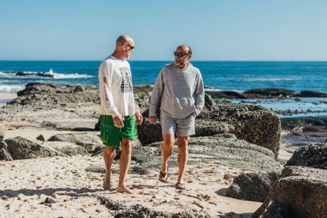 Two men walking near the water | Photo by Kindel Media/Pexels