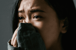 Anxious Asian woman with her hands covering her mouth | Photo by MART PRODUCTION