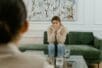 a sad woman sitting on a couch in front of her therapist | Photo by Mart Production/Pexels