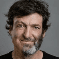 Man with a half beard smiling.