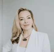 Blonde woman in white blazer smiling