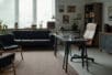 An empty therapist office with a desk, two chairs, and a couch
