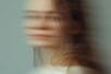 The blurred face of a woman turning to face the camera
