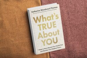 A copy of the book What's True About You sits on a wooden table