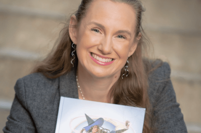 Megan Connell holding a D&D book and smiling to camera